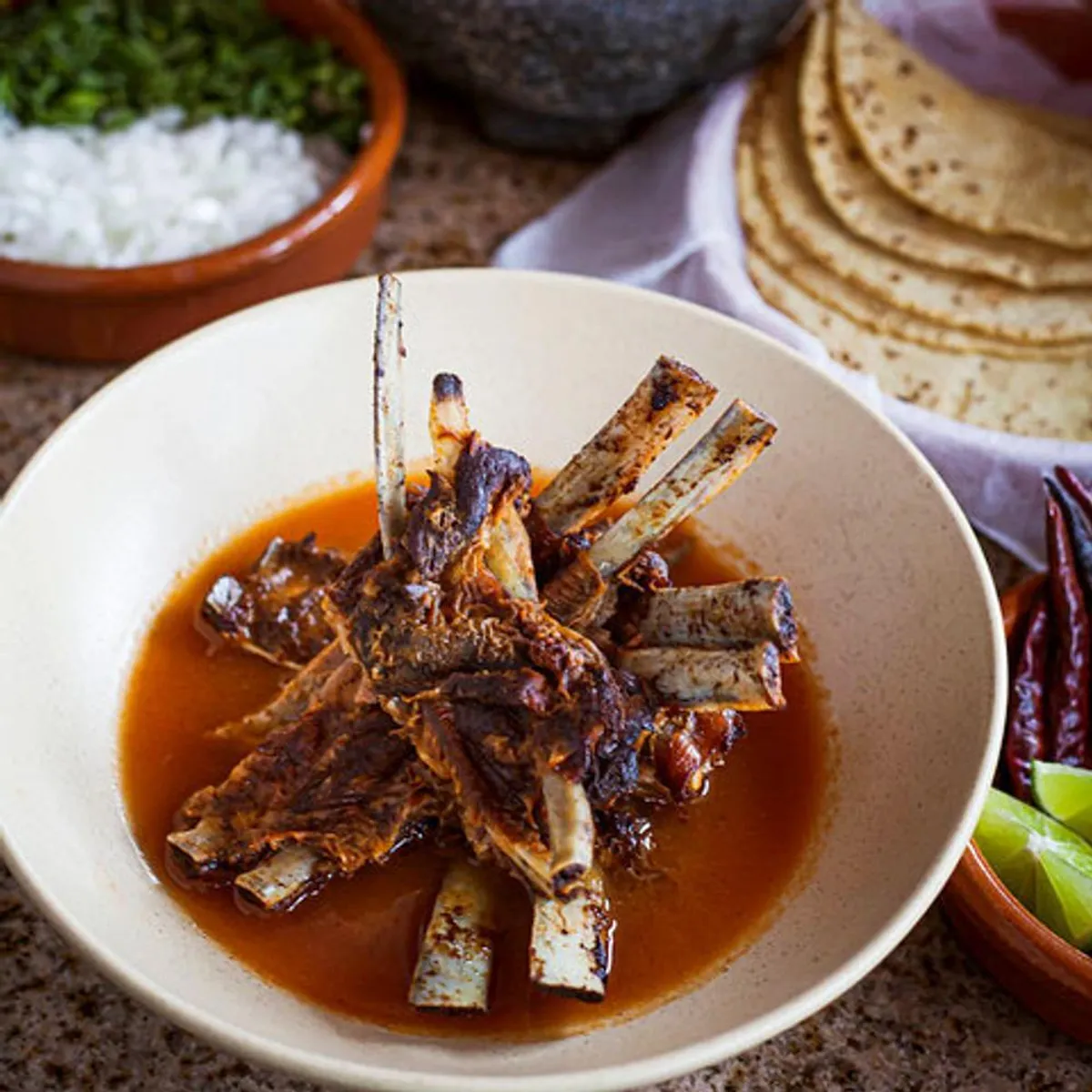 Birrieria Zaragoza goat birria with consommé and fresh garnishes